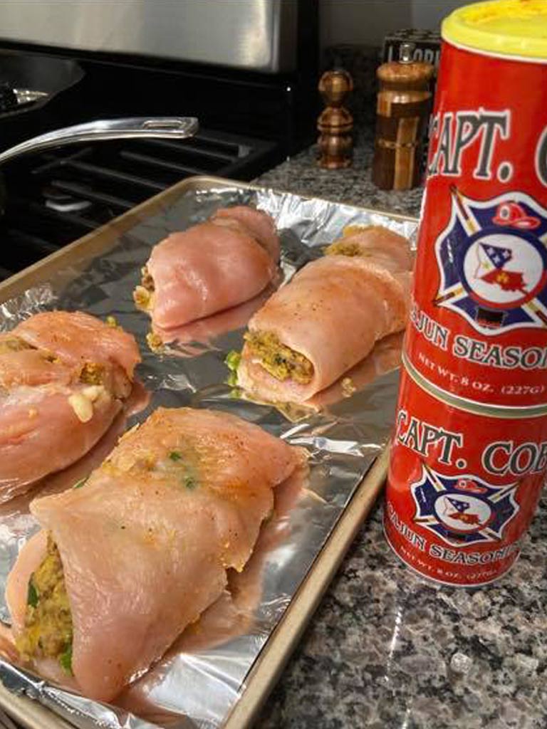 A pan of stuffed chicken seasoned with Captain Coby's Cajun Seasoning prepared for the oven.